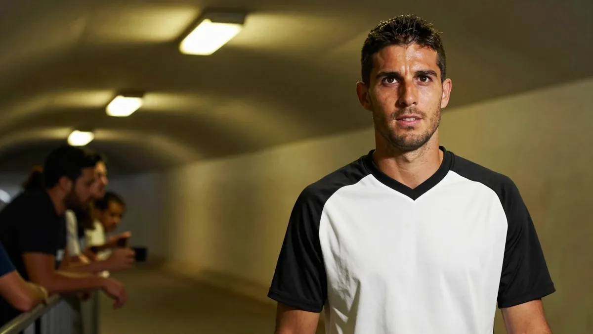 A 35-year-old, 5'10" Telstar midfielder in a black and white plain, cotton training top, with a determined expression...